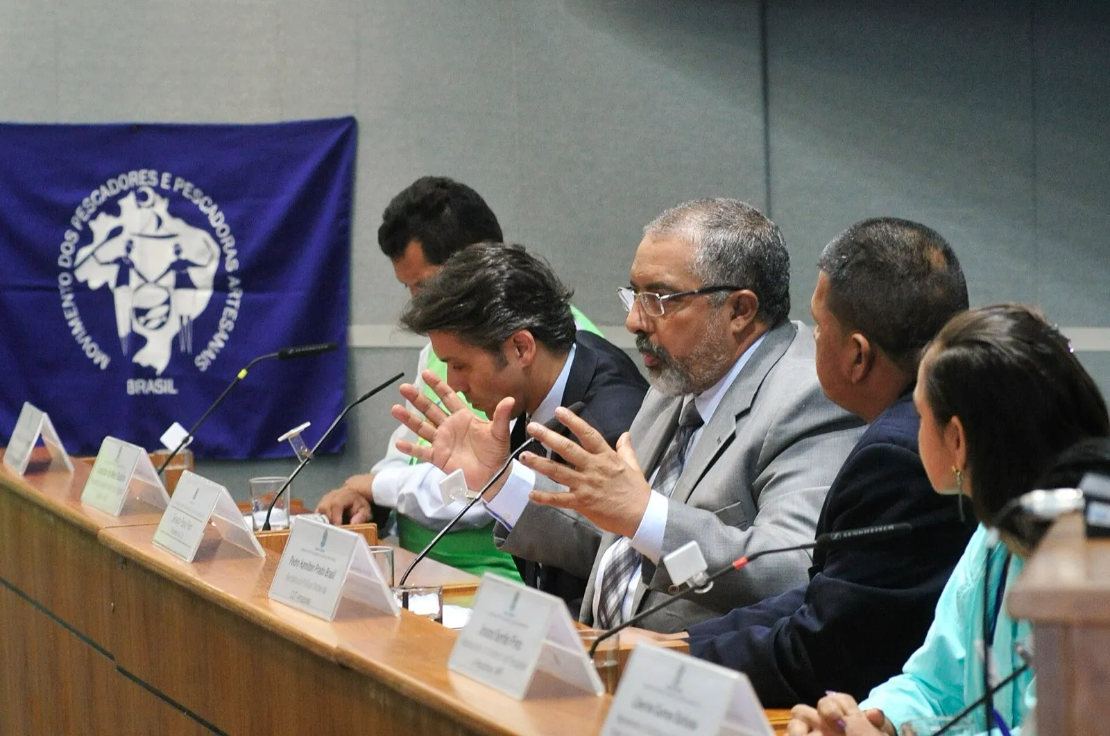 Senador Paulo Paim fala ao lado de representantes de pescadores durante audiência pública no Senado.