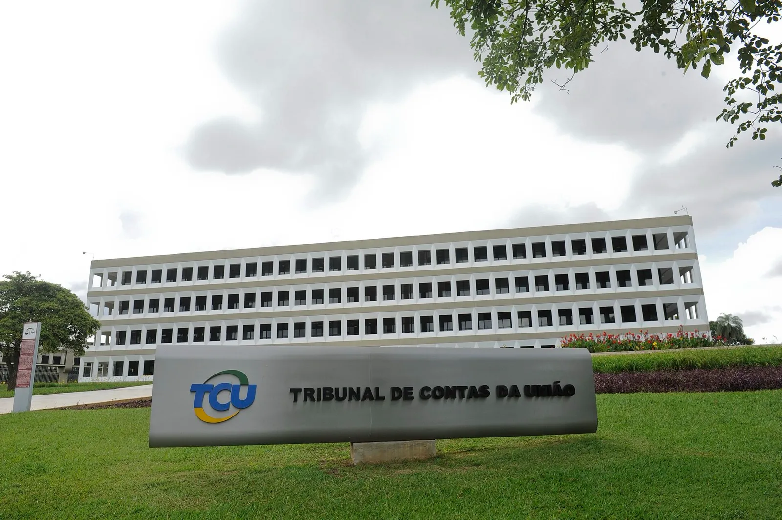 Fachada do Tribunal de Contas da União, com o logotipo e o nome do órgão sobre o gramado.